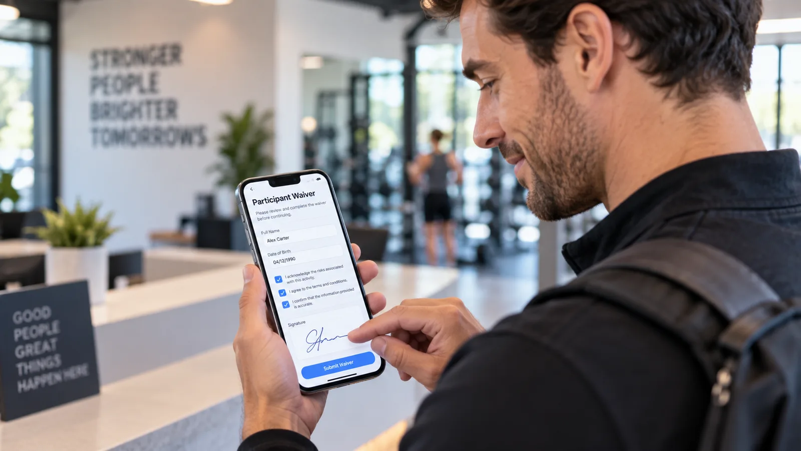 Gym visitor signing a digital participant waiver on a smartphone at the front desk